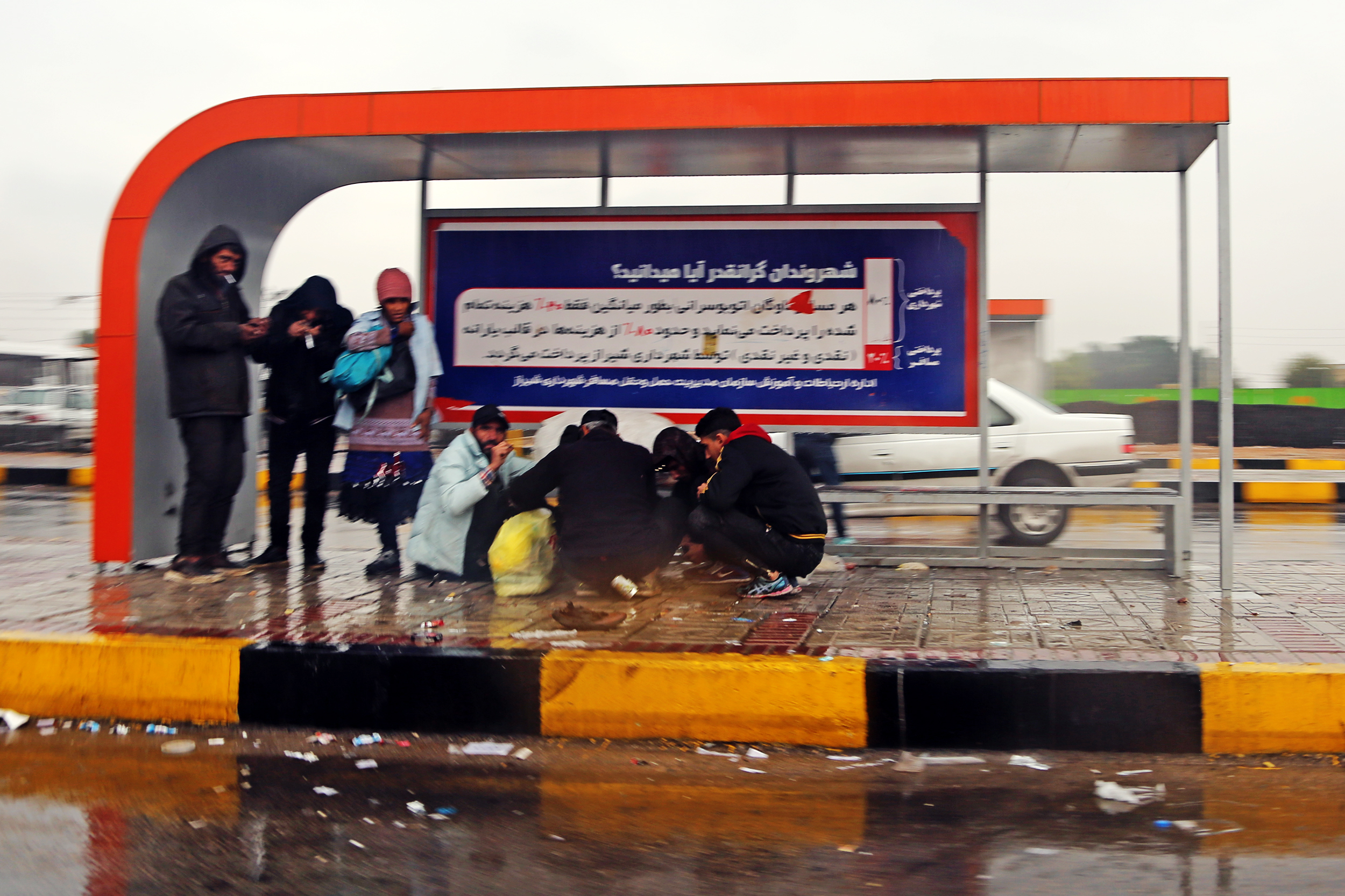 ایستگاه اتوبوس به جای گرمخانه ها؛ پناهگاه بی خانمان ها زیر باران! – عکاس: عباس امیری